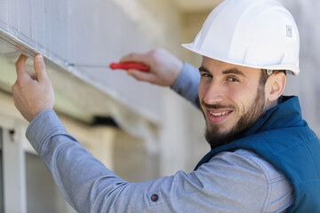 portrait of a happy electrician on a ladder