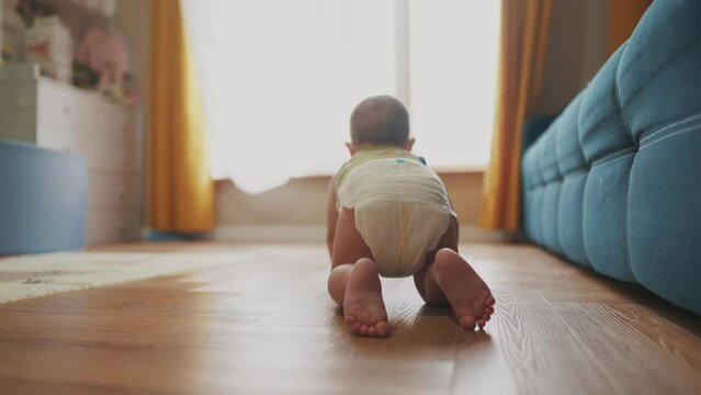 baby newborn crawling on the floor. happy family kindergarten kid concept. First steps, baby crawling view from the back. baby learns to crawl to explore lifestyle the world dream. first steps creeps