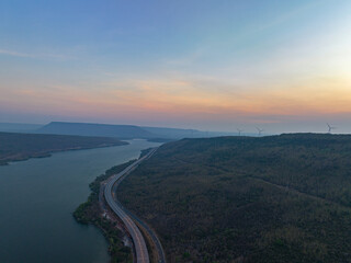 .aerial view light on super highway Along the Lam Takhong Dam at twilight..view of natural scenery beside the road..dams and wind turbines that generate electricity..blue water and beautiful sky