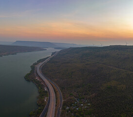 .aerial view light on super highway Along the Lam Takhong Dam at twilight..view of natural scenery beside the road..dams and wind turbines that generate electricity..blue water and beautiful sky