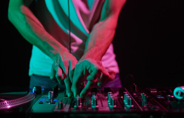 Club DJ playing music on stage. Close up photo of professional disk jokey mixing musical tracks...