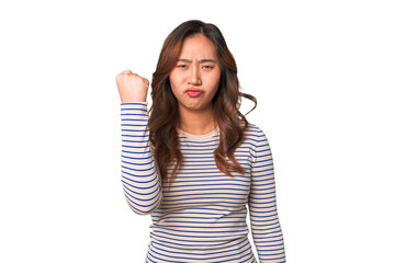 A young chinese woman showing fist to camera, aggressive facial expression.