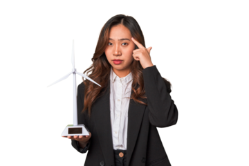A young Chinese businesswoman proudly holds a windmill, symbolizing her commitment to renewable energy and sustainable development.