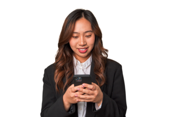 A young Chinese businesswoman looks happy while glancing at her phone, likely enjoying the convenience and connectivity of modern technology.