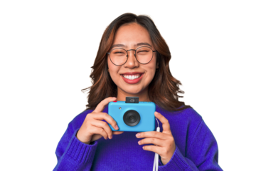Happy Asian woman holding a retro camera.