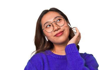 A young asian woman listening to music with wireless earbuds