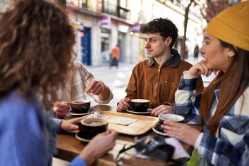 A multicultural group of friends enjoying coffee and tea after their vacation.