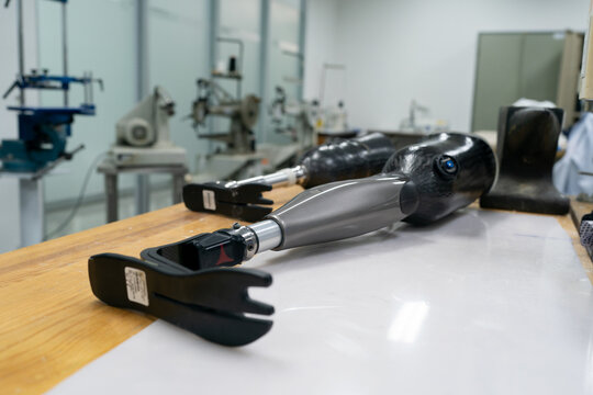 Production of a prosthetic leg. A woman creates part of the leg. An engineer is testing the mechanical joint of a prosthetic leg. New sports body part.