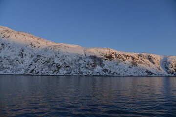 Mountains in the northern part of Norway, at the outlet to the ocean. Incredible sunset
