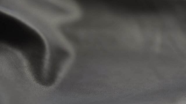 Slow motion closeup slide shot of soft gray brown leather