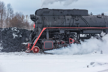 Retro steam locomotive before coal loading at winter morning.