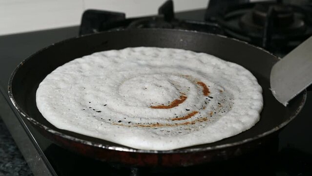 Preparing dosa breakfast in a pan.