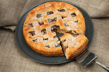 shortcake with plums on a wooden table. the concept of homemade shortcrust pastry. baked fruit dessert on the kitchen table close up