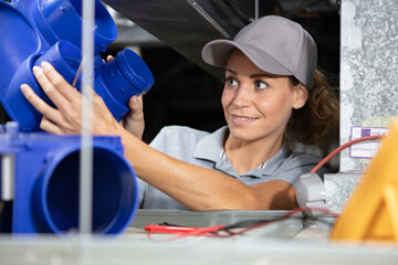 female electrician fixing ceiling wiring
