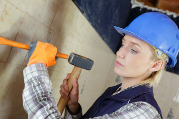 woman hammering nail into wall