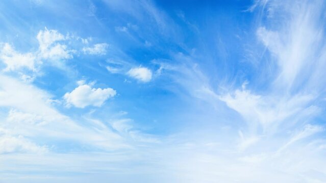 Light white clouds fly across a bright blue sky. Clear sky at sunny summer afternoon. Spring cloudscape background. Copy space, 4K Sky Time lapse, Beautiful background, Sky Timelapse of skyscrapers.