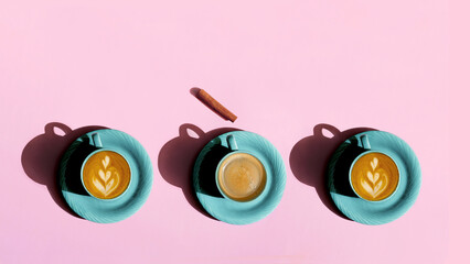 Cups with coffee and cappuccino on a pink background
