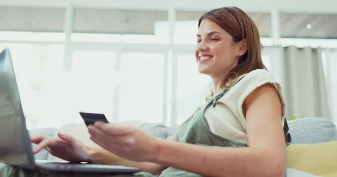 Happy woman, laptop and credit card for online shopping, ecommerce or purchase on living room sofa at home. Female shopper smiling for internet banking, wireless transaction or bank app on couch