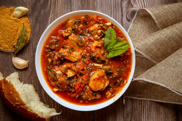 Chicken in tomato sauce with seasoning and parsley.