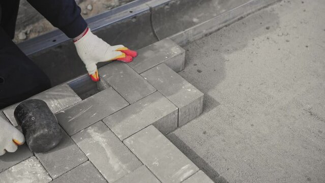 worker lays new paving slabs