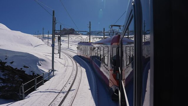 Riding the iconic cogwheel Gornergrat railway in Zermatt ski resort in the Swiss Alps in Valais, Riding a train in Switzerland on a sunny winter day