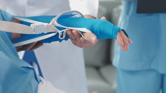 Man with broken arm in cast lying on bed in hospital. The emergency center treatment is plaster and hangs with sling for a further cure in an orthopedic clinic. Patient pain from accident injury.