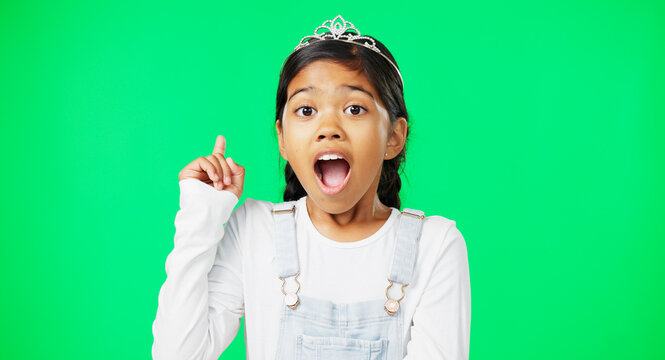 Green screen, idea and portrait of surprised child feeling excited, happy and isolated in a studio background. Smart, clever and young girl or kid pointing up at brand, product placement or mockup