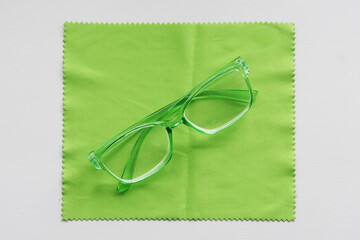 Green glasses on a cleaning cloth.
