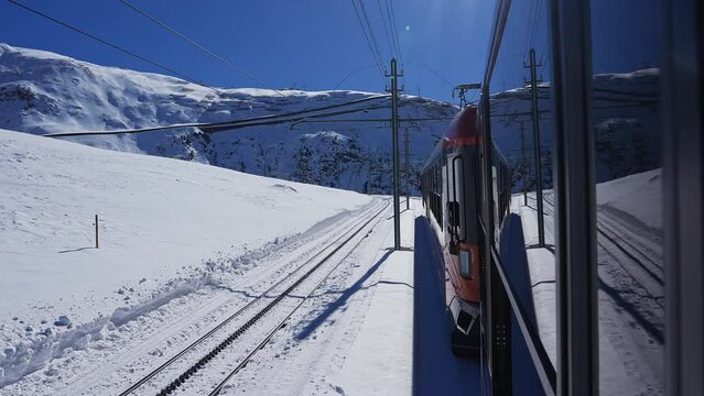 Riding the iconic cogwheel Gornergrat railway in Zermatt ski resort in the Swiss Alps in Valais, Riding a train in Switzerland on a sunny winter day