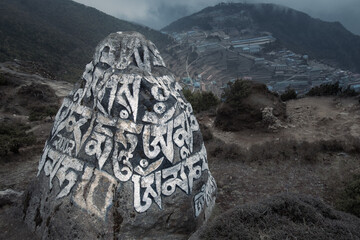 Mani stone with carved Buddhist mantras in front of Sherpa town in Himalayas, Nepal, Namche Bazaar