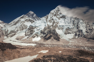 Mount Nuptse and Everest base camp yellow tents on Khumbu glacier under dramatic sky, Nepal, Himalaya