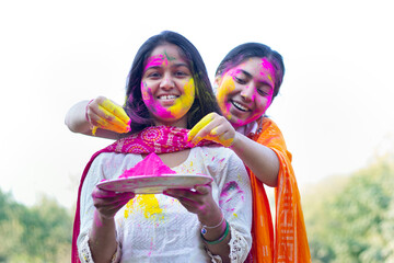 Two Indian teenage girls playing Holi during Holi Color festival
