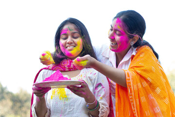Two Indian teenage girls playing Holi during Holi Color festival