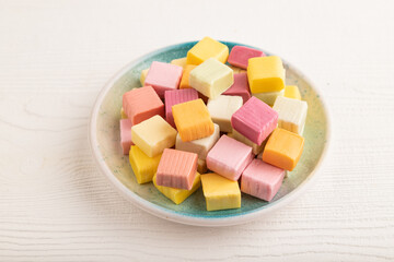 Various fruit jelly chewing candies on white wooden. apple, banana, tangerine, side view.