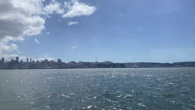 Downtown San Francisco and Sutro Tower, with a sailboat in the foreground as seen from the San Francisco Bay on a beautiful, sunny day.