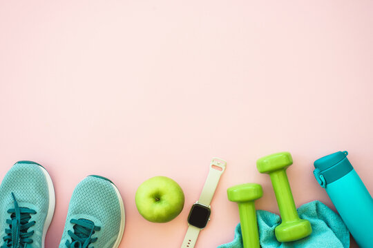 Fitness equipment on pink background, flat lay image.