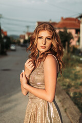 Beautiful ginger teen girl in glamorous golden dress. Ready for her prom night. © stivog