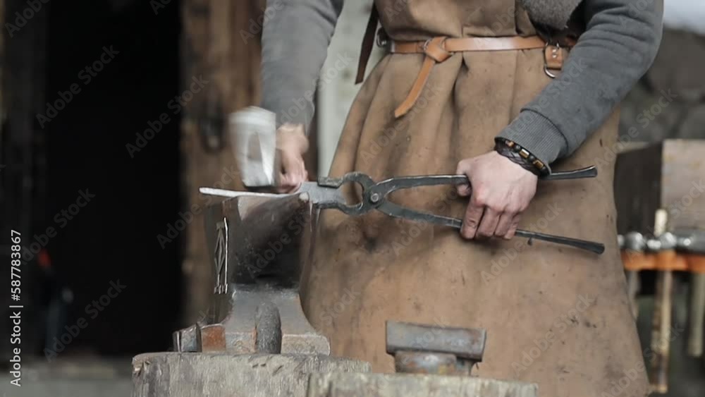 Poster blacksmith forging a workpiece on an anvil with a hammer