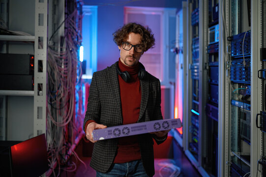 Portrait of it specialist holding hardware in hand standing in server room