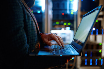 IT technician checking the servers vitals using laptop computer - obrazy, fototapety, plakaty