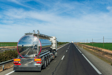 Truck with food cistern and the rear of the vehicle with mirror effect circulating on the highway.