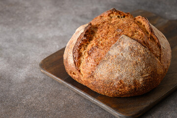 Loaf of wholegrain sourdough bread on gray background. Close up.