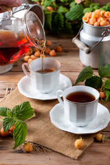 Cup of tasty raspberry tea on wooden table. Useful drink for health. Herbal tea. Traditional medicine.