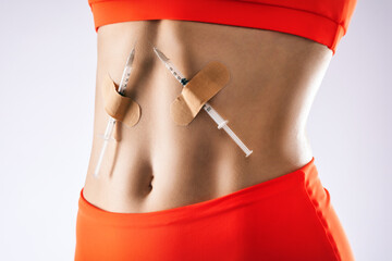 The girl has two injection syringes glued on her stomach. Drug addiction treatment. Insulin...
