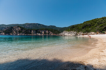 Panorama of beautiful Rovinia Beach with turquoise water and rocks during summer vacations, Corfu, Greece