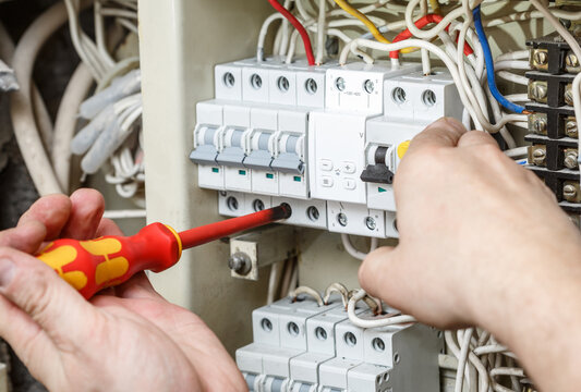 Electrician professional working on electric equipment installation and cheking.