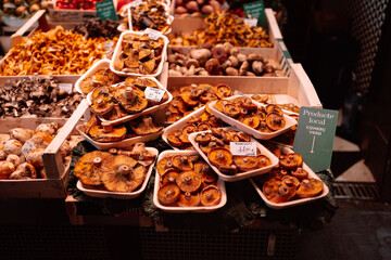 Fresh mushroom on a farmers local market for gourmet, crates food unhealthy but tasty colorful marmalade candies with a lot of sugar food background of market counter ready for selling in the Boqueria
