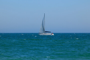 Naklejka premium Blue Mediterranean Sea, clear skies and a sailing ship with white sailing. Regata