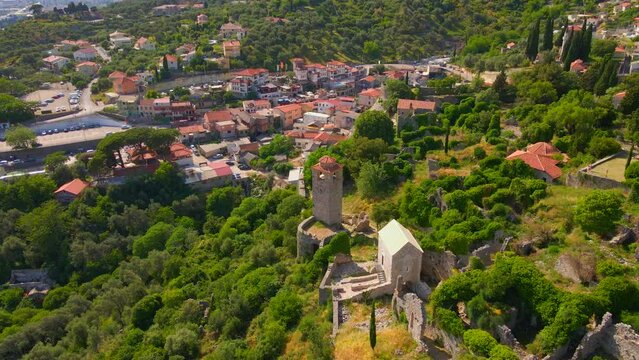 The drone footage captures the stunning ruins of Stari Bar, with stone buildings and a prominent clock tower standing tall amidst the remnants of history. The Old Bar in Montenegro is a fascinating