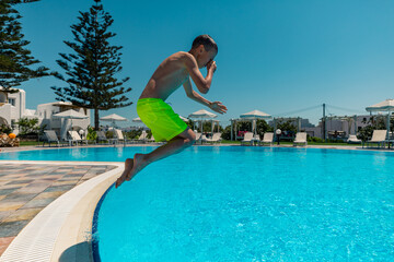 Naxos, Grece - July 20, 2020 - Boy jumping to the pool in the small family hotel on Naxos Island